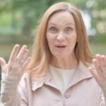 Middle-aged woman looking upset with her hands up