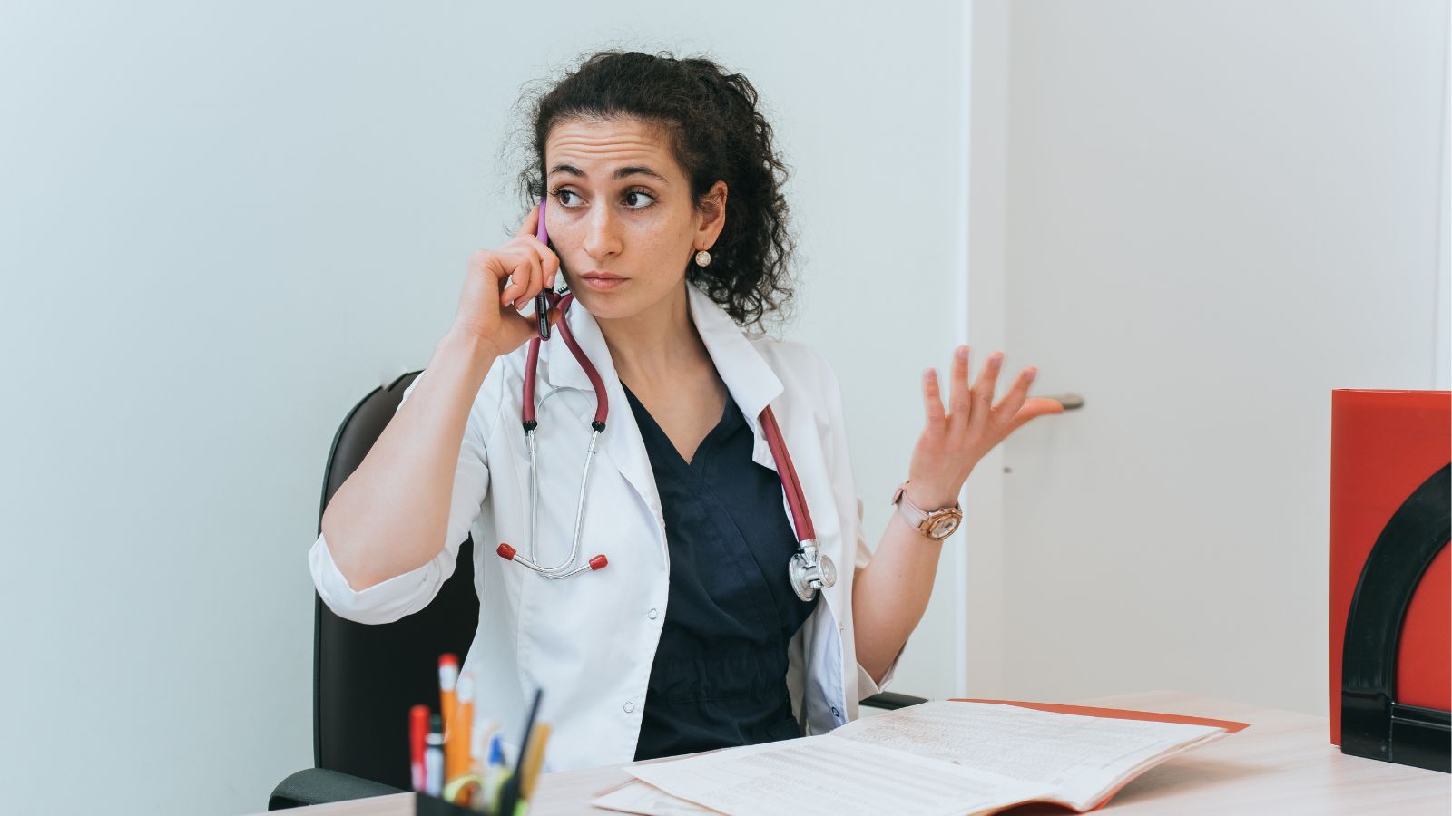 Medical professional talking on the phone and looking annoyed