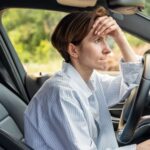 Woman sitting in car looking annoyed