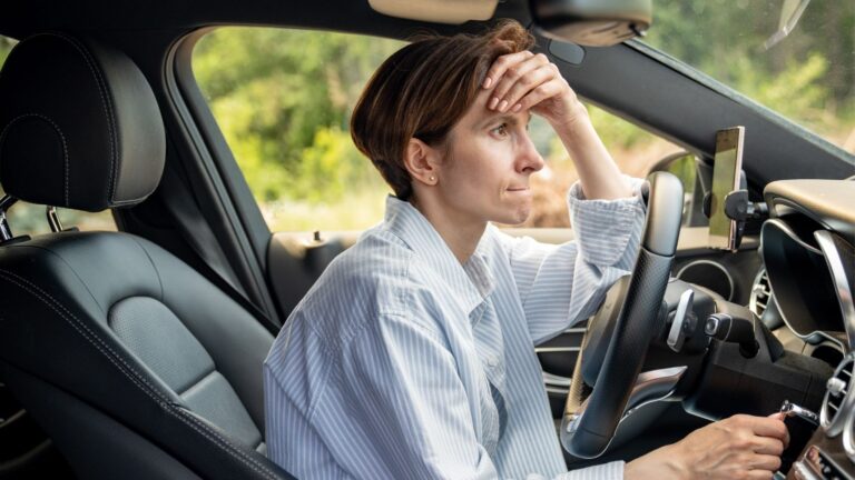 Woman sitting in car looking annoyed