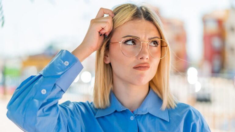 Blonde woman scratching her head