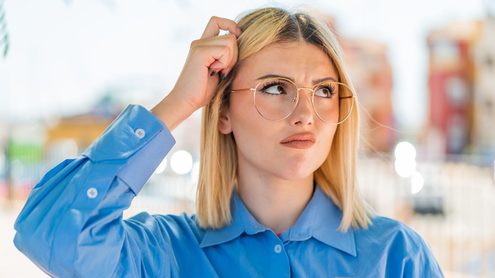 Blonde woman scratching her head