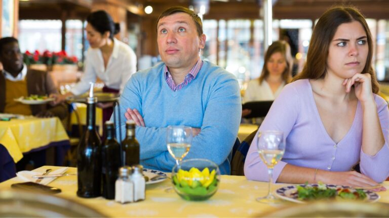 Couple sitting at a restaurant appearing to be in a fight