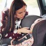 Mom in the backseat checking on her toddler in carseat