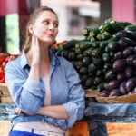 Woman standing at farmer's market looking annoyed