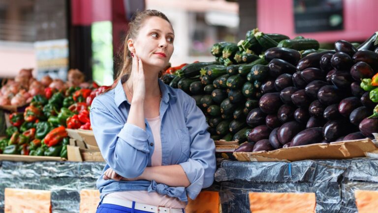 Woman standing at farmer's market looking annoyed