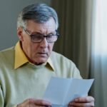 Older man reading a letter and looking upset