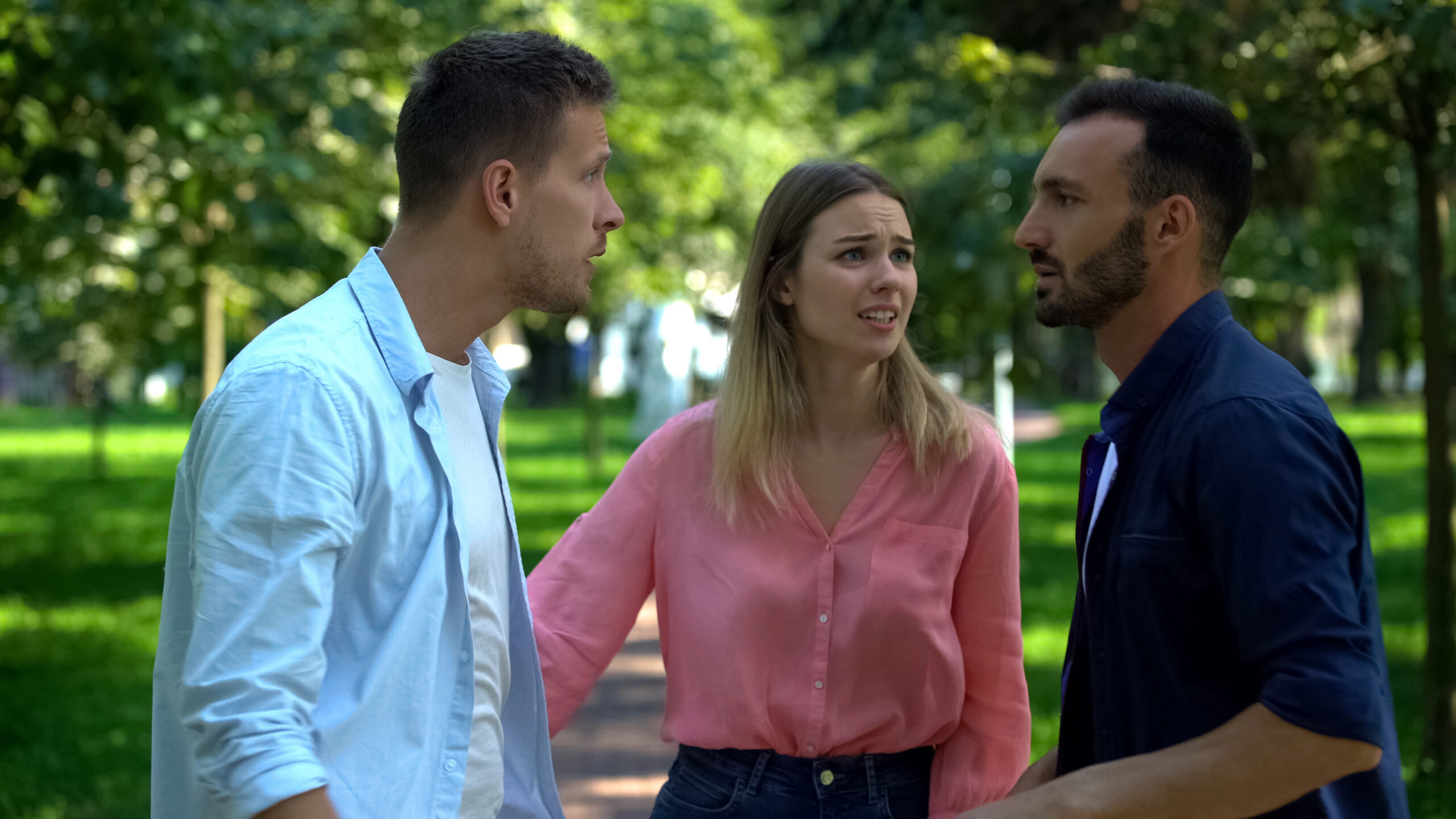 Two men arguing with a woman standing in between