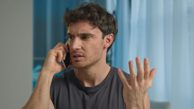 Young man talking on the phone looking angry