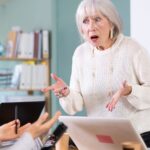 Older boss yelling at young woman employee