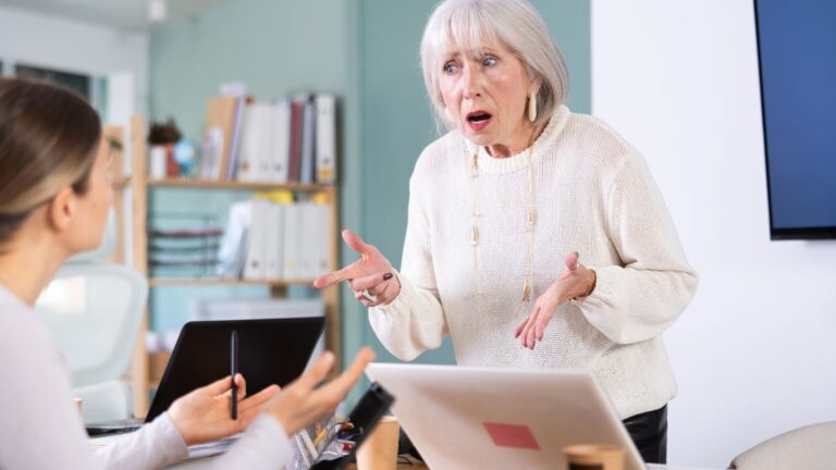 Older boss yelling at young woman employee