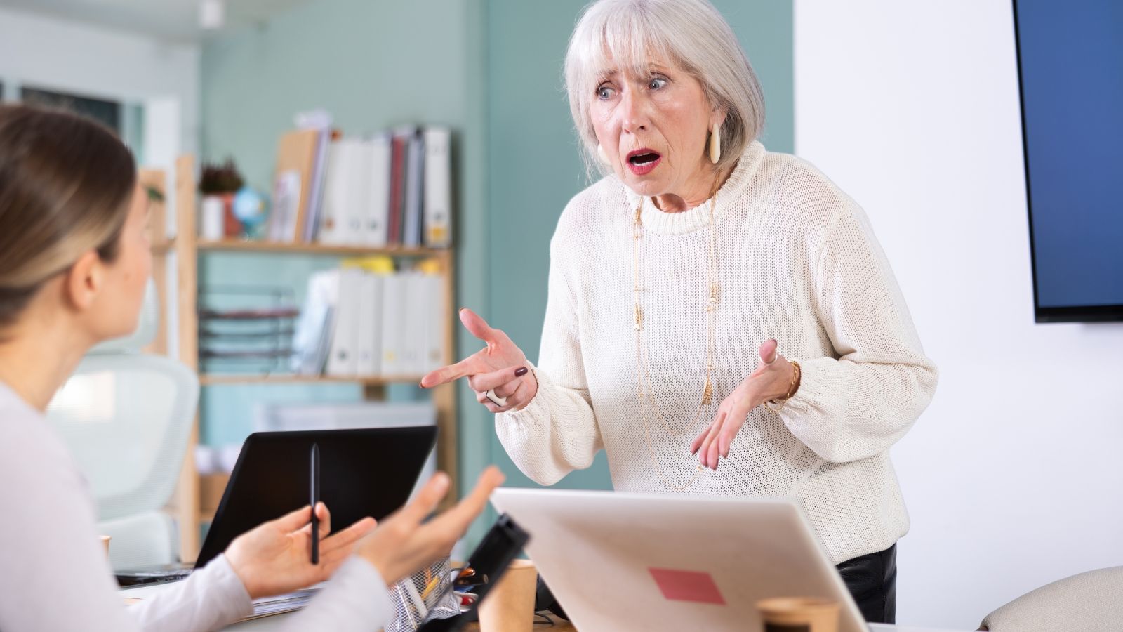 Older boss yelling at young woman employee