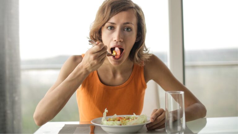 Woman eating lunch by herself looking slightly annoyed