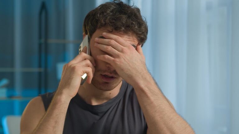 Man on phone looking upset