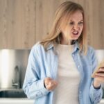 Woman angry while sending an email on her phone