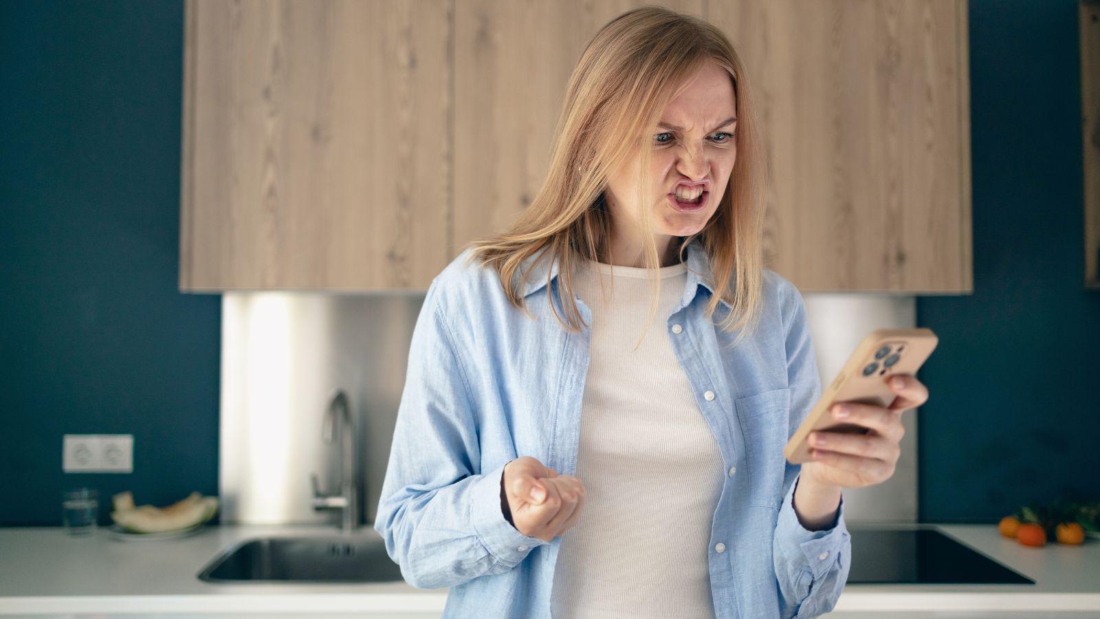 Woman angry while sending an email on her phone