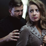 Woman looking uneasy with a man grabbing her arm