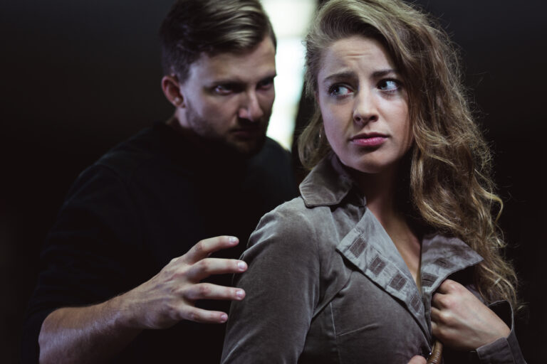 Woman looking uneasy with a man grabbing her arm