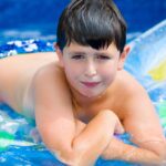 Teenage boy floating on a raft in a pool