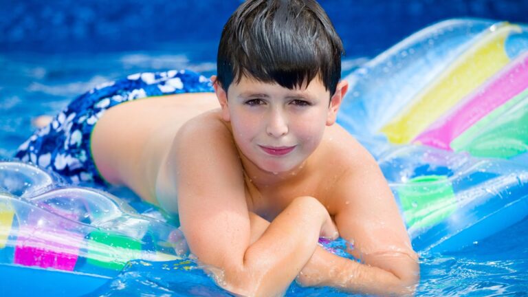 Teenage boy floating on a raft in a pool
