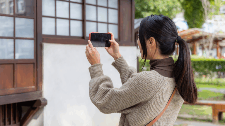 Woman taking a picture of the outside of a house