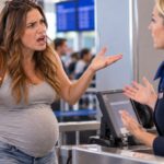 Pregnant woman looking upset with flight attendant