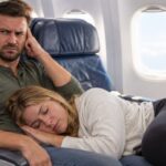 Woman sleeping on a man's lap on an airplane