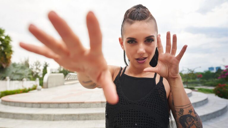 Woman with tattoos holding her hands out