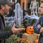 Male neighbors arguing outside in front of Halloween decorations