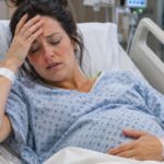 Pregnant woman in a hospital bed looking sick